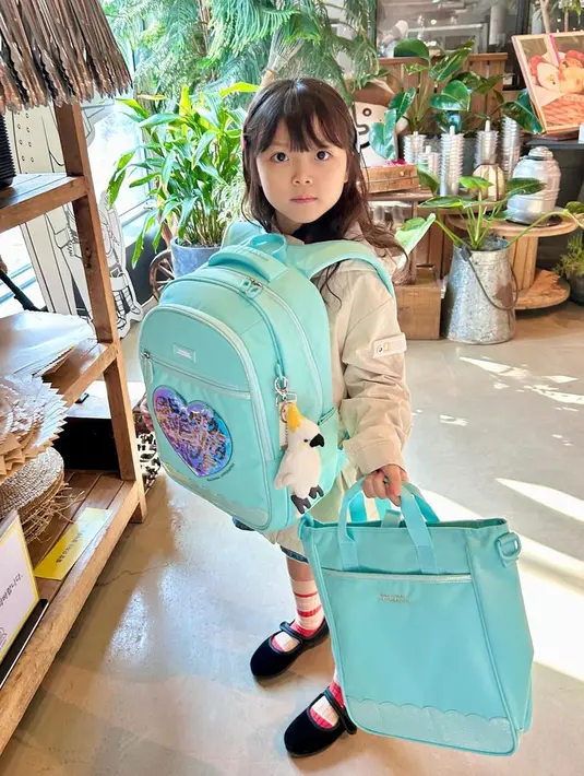 Sang ibunda juga kerap berbagi aktivitas Han Yeoreum saat pergi ke sekolah. Ia tampil menggemaskan dengan satu set tas punggung dan tas tenteng berwarna biru cerah. Rambut cokelatnya yang panjang dan berponi membuat 'baby Sol' semakin manis diusianya saat ini. (Liputan6.com/IG/@k_han__na)