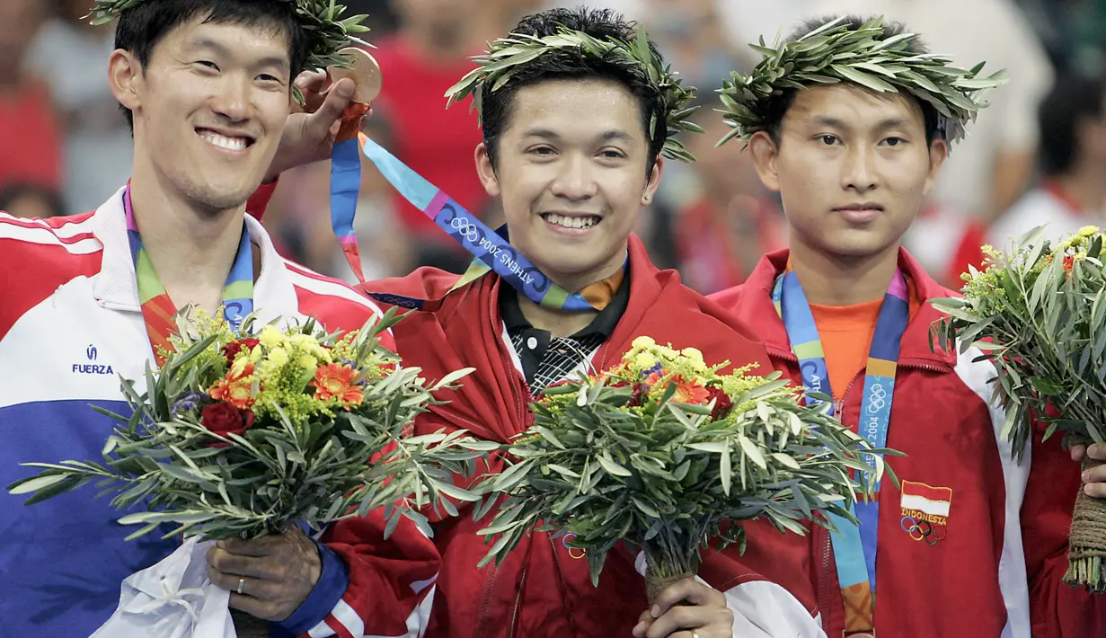 Pebulutangkis tunggal putra, Taufik Hidayat (tengah) berhasil kalahkan Shon Seung-mo dari Korea Selatan di babak final Olimpiade Athena 2004. Dirinya menjadi satu-satunya kontingen yang mampu bawa medali emas untuk Indonesia di ajang Olimpiade itu. (Foto: AFP)