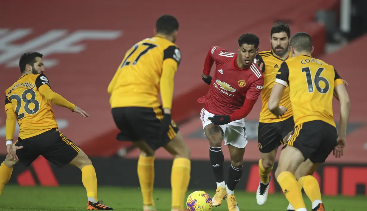 Penyerang Manchester United, Marcus Rashford membawa bola dari kawalan empat pemain Wolverhampton Wanderers pada pertandingan lanjutan Liga Inggris di Stadion Old Trafford, Rabu (30/12/2020). (Martin Rickett, Pool via AP)