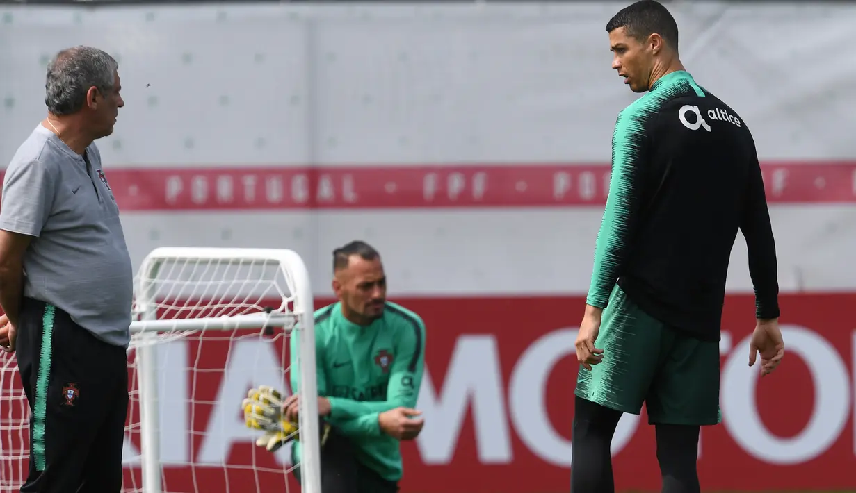 Pelatih Portugal, Fernando Santos (kiri) memberikan instruksi kepada Ronaldo pada sesi latihan di Kratovo, Moskow, (12/6/2018). Portugal akan mejalani laga perdana grup B melawan Spanyol. (AFP/Francisco Leong)