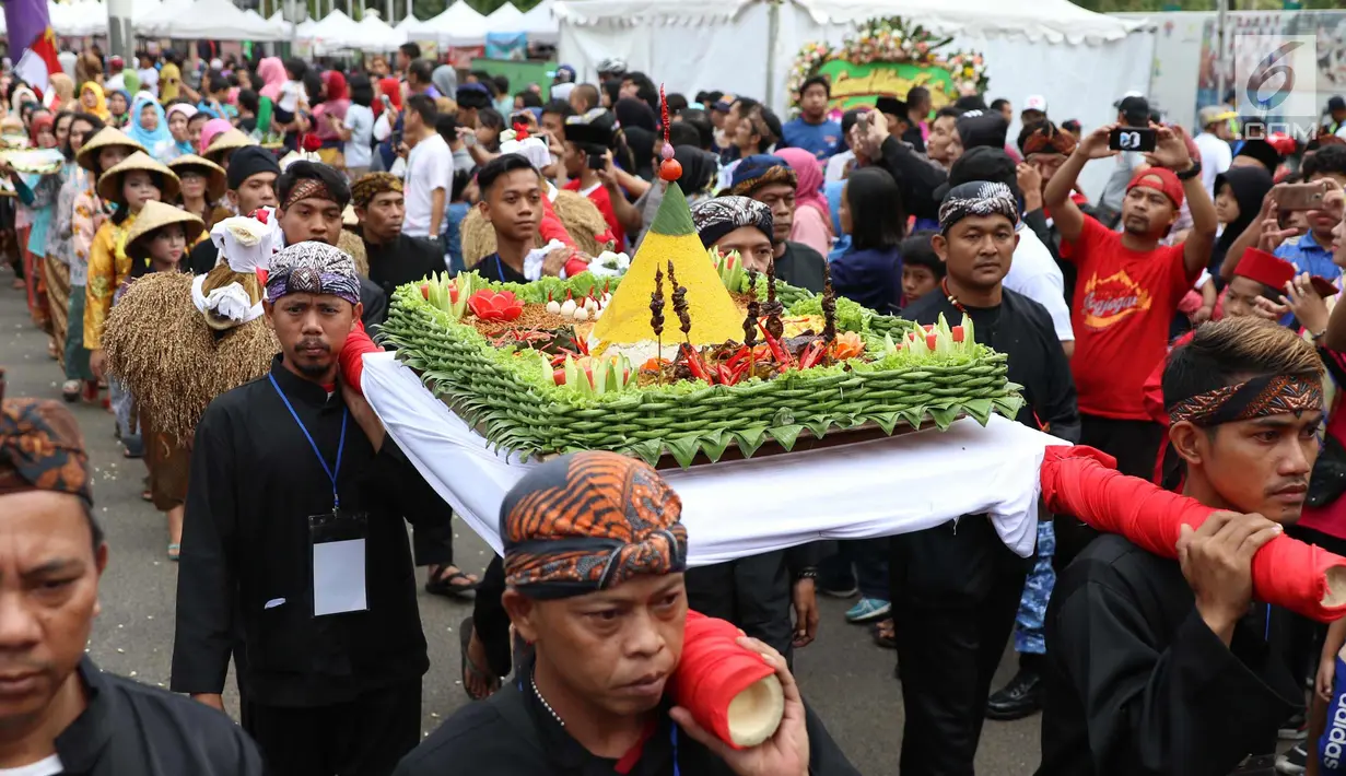 Sejumlah masyarakat mengenakan pakaian adat dan melakukan karnaval di jalan Pintu 1 Senayan, Jakarta, Minggu (24/9). Karnaval tersebut dilakukan dalam rangka HUT Gelora Bungkarno yang ke-55. (Liputan6.com/Angga Yuniar)