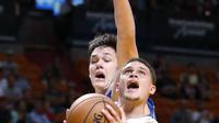 Pemain Miami Heat, Tyler Johnson #8 mencoba melakukan tembakan saat dihadang pemain Orlando Magic, Stephen Zimmerman Jr. pada laga NBA preseason basketball game, di Miami (19/10/2016) WIB. (AP/Wilfredo Lee)