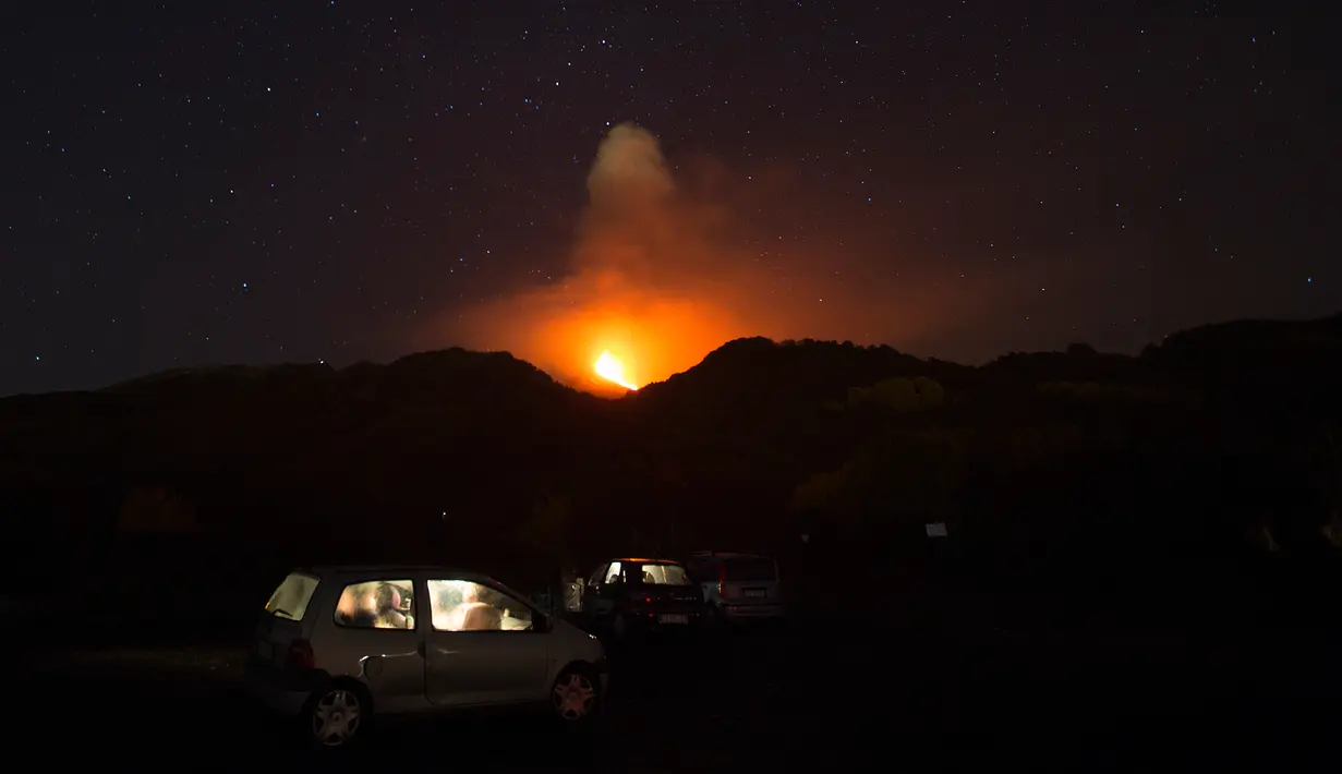 Warga menyaksikan Gunung Etna mengeluarkan lava panas saat meletus di pulau selatan Sisilia, Italia, Senin (7/12). Gunung berapi tertinggi di Eropa itu kembali memuntahkan abu vulkanik setelah dua tahun tidak ada aktivitas. (REUTERS/Antonio Parrinello)