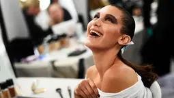 Bella Hadid tertawa usai dipakaikan make-up di belakang panggung Blenheim Palace pada peragaan busana kolehsi Dior, Cruise 2017 di Woodstock, Inggris, 31 Mei 2016. (REUTERS/Dylan Martinez)