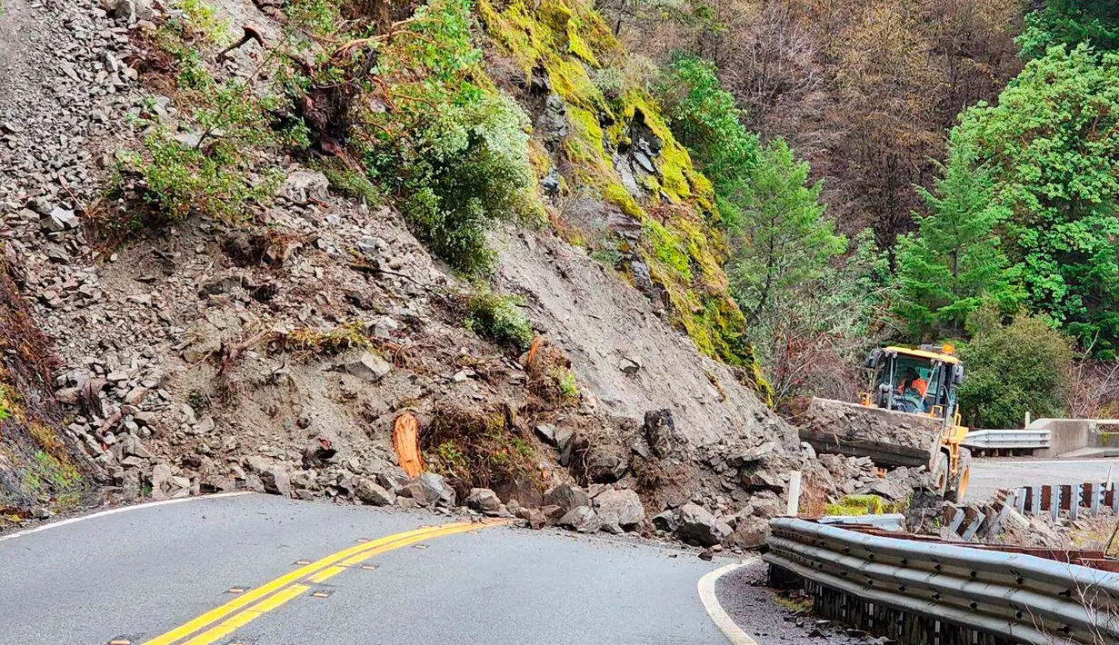 Pengawas Pemeliharaan Distrik 2 Weaverville menunjukkan alat berat memindahkan longsoran batu di State Route 299, Trinity County, antara Burnt Ranch dan Hawkins Bar di Burnt Ranch, California, Amerika Serikat, 31 Desember 2022. Badai dahsyat yang menerjang California menyebabkan banjir, pohon tumbang, hingga tanah longsor. (Micah Crockett/Caltrans District 2 via AP)