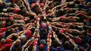 Kompetisi Taragon Castells terinspirasi dari kegiatan kelompok penari pada abad ke-18, Spanyol, Sabtu (1/10). Tim dinyatakan menang apabila berhasil membuat menara manusia yang tertinggi. (AFP PHOTO / Lluis Gene)