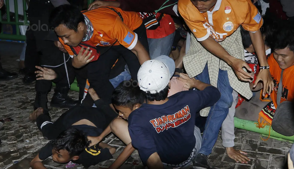 Para Jakmania terjatuh saat berusaha masuk stadion Patriot, Bekasi, Minggu (12/11/2017). Pertandingan terakhir Persija di Liga 1 2017 ini membuat antusias Jakmania semakin tinggi untuk datang menyaksikan laga. (Bola.com/ M Iqbal Ichsan)