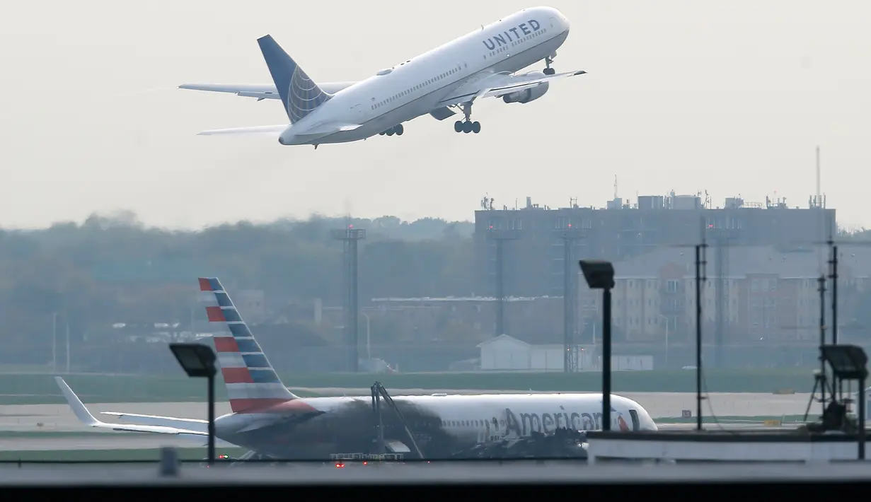 Pesawat American Airlines yang terbakar di Bandara O'Hare Chicago, Illinois, AS (28/10). Federal Aviation Administration (FAA) mengatakan pesawat jenis Boeing 767 yang hendak terbang ke Miami mengalami pecah ban dan kerusakan mesin. (REUTERS/Jim muda)