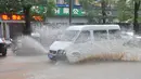 Sebuah mobil menerobos jalan yang tergenang air di Wilayah Pan'an, Kota Jinhua, Provinsi Zhejiang, China timur (4/8/2020). Topan membawa angin berkecepatan 38 meter per detik di dekat pusatnya. (Xinhua/Kong Debin)