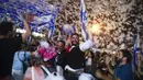Warga Israel merayakan pelantikan pemerintahan baru di Tel Aviv, Israel, Minggu (13/6/2021). Parlemen Israel telah memberikan suara mendukung pemerintahan koalisi baru yang secara resmi mengakhiri 12 tahun pemerintahan bersejarah Perdana Menteri Benjamin Netanyahu. (AP Photo/Oded Balilty)