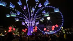Orang-orang melihat sebuah instalasi seni yang diterangi cahaya dalam festival cahaya tahunan bernama Fete des Lumieres di Lyon, Prancis, 7 Desember 2017. Festival ini berlangsung bertepatan dengan musim liburan Natal. (AFP PHOTO / PHILIPPE DESMAZES)