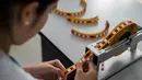 Petugas medis, Leidy Garcia menyiapkan potongan pita yang ditandai dengan koordinat Braille yang akan digunakan untuk pemeriksaan payudara di sebuah rumah sakit di Cali, Kolombia (14/11). (AFP/Luis Robayo)