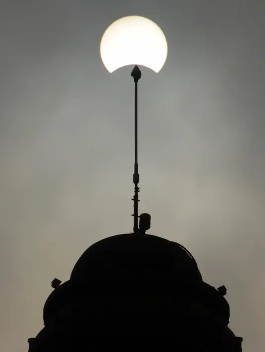 Bulan melintas di depan matahari saat gerhana matahari parsial di Phnom Penh (9/3/2016). Gerhana matahari total terjadi di sejumlah daerah di Indonesia. (AFP Photo/Tang Chhin Sothy)