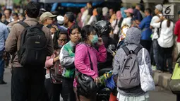 Antraen panjang masyarakat yang hendak menaiki bus Transjakarta di depan Cibubur Junction, Jakarta, Senin (16/4). Aturan ganjil genap tersebut diterapkan untuk mengurai kemacetan di ruas Tol Jagorawi. (Liputan6.com/Faizal Fanani)