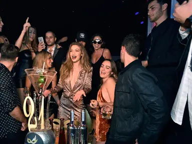 Model Gigi Hadid (tengah) bergembira merayakan ulang tahunnya yang ke-21 dengan teman-teman di Intrik Nightclub di Wynn Las Vegas, Nevada ( 30/4). Mengenakan mini dress berwarna coklat gigi hadid tampak seksi dan cantik. (AFP PHOTO/David Becker)