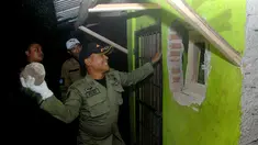 Petugas  menggerebek tempat penjualan dan pembuatan miras di Cicalengka, Kabupaten Bandung, Minggu (8/4). Penggerebekan toko miras di enam titik wilayah Cicalengka dilakukan pasca meninggalnya 15 orang akibat menenggak miras oplosan. (Timur Matahari/AFP)