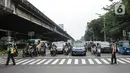 Petugas gabungan Polisi dan Dishub memberhetikan pengguna jalan untuk Mengheningkan sejenak di Kawasan Jalan Fatmawati Jakarta, Sabtu (10/7/2021). Kegiatan mengheningkan cipta selama 60 detik tersebut bentuk penghormatan kepada mereka yang telah wafat karena covid-19. (Liputan6.com/Faizal Fanani)