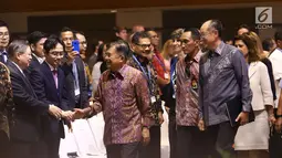Wakil Presiden RI Jusuf Kalla bersalaman dengan peserta saat tiba menghadiri Dialog Tingkat Tinggi tentang Pembiayaan dan Asuransi Risiko Bencana selama acara IMF-World Bank Group 2018, Bali, Rabu (10/10). (Liputan6.com/Angga Yuniar)