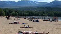 Orang-orang berjemur di pantai di Loch Morlich dekat Aviemore, di Skotlandia, (28/5). Cuaca panas tengah melanda sebagian besar wilayah di Inggris. (AP Photo/Jane Barlow)