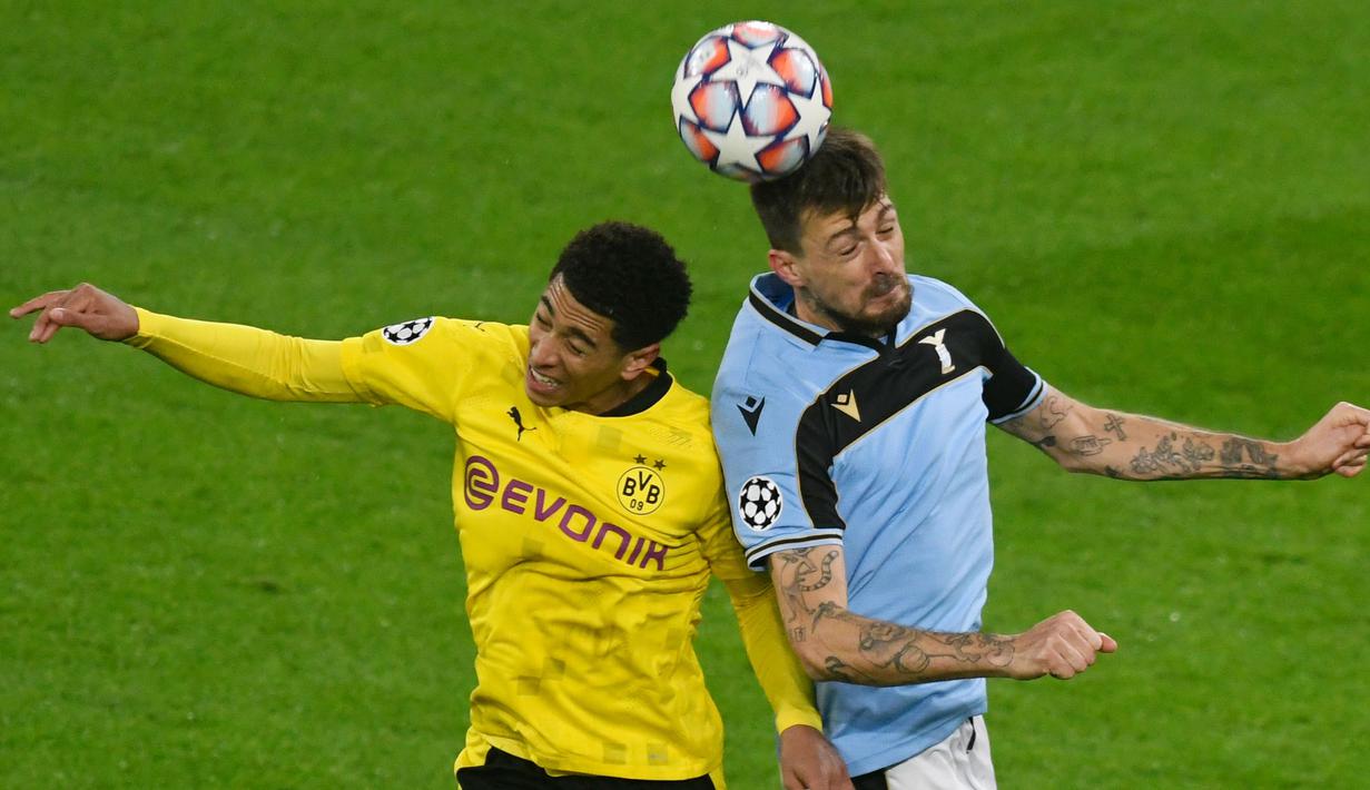 Gelandang Borussia Dortmund, Jude Bellingham (kiri), berduel udara dengan bek Lazio, Francesco Acerbi dalam laga lanjutan Liga Champions 2020/21 Grup F di Signal Iduna Park Stadium, Dortmund, Rabu (2/12/2020) waktu setempat. Dortmund bermain imbang 1-1 dengan Lazio. (AFP/Ina Fassbender)
