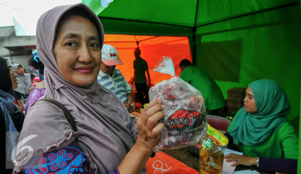  Warga menunjukan daging sapi yang dijual dalam operasi pasar murah PD Pasar Jaya, Jakarta, Kamis (9/6/2016). Pasar murah menjual daging sapi paha belakang di harga Rp89 ribu/kg dan untuk daging sapi paha depan Rp85 ribu/kg. (Liputan6.com/Yoppy Renato)