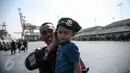 Seorang personel TNI-AD berpose dengan anaknya di Pelabuhan Kolinlamil, Jakarta, Senin (9/5). Sebanyak 450 personel TNI-AD dari Satgas Yonif Para Raider 330 inf 1 Kostrad dilepas untuk misi pengamanan perbatasan RI-PNG. (Liputan6.com/Faizal Fanani)