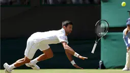 Petenis Serbia, Novak Djokovic, melempar raketnya saat berusaha menjangkau bola pukulan petenis AS, Sam Querrey, dalam turnamen tenis Wimbledon di All England Lawn Tennis & Croquet Club, Wimbledon, Inggris, (2/7/2016). (Reuters/Paul Childs)