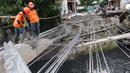 Petugas Suku Dinas Bina Marga Jakarta Barat memperbaiki Jembatan Kali Inspeksi Grogol, Jakarta, (30/5/2016). Pergeseran tanah di bawah Kali Irigasi Grogol sehingga pondasi jembatan bergeser dan permukaan jalan ambles. (Liputan6.com/Helmi Afandi)