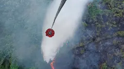 Sebuah helikopter melakukan pengeboman air untuk memadamkan kebakaran lahan gambut di Danau Lamo, Provinsi Jambi, Indonesia, pada hari Senin, 24 Agustus 2026. (BPBD Jambi via AP)