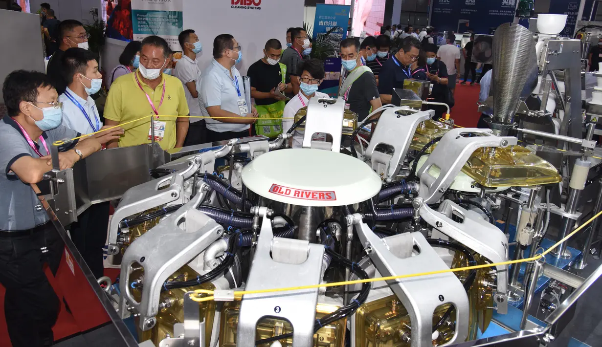 Para pengunjung mengamati mesin pengolah makanan dalam Pameran Industri Daging Internasional China ke-18 di Qingdao, Provinsi Shandong, China, 10 September 2020. (Xinhua/Li Ziheng)