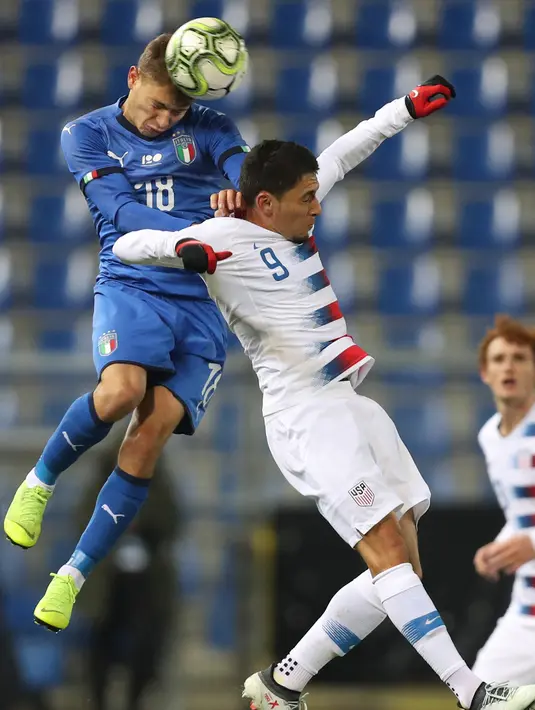 Gelandang Italia, Nicolo Barella berusaha menyundul bola dari kawalan pemain Amerika Serikat, 'Marky Delgado selama pertandingan persahabatan di Cristal Arena di Genk, Belgia (20/11). Italia menang tipis atas AS 1-0. (AP Photo / Francisco Seco)