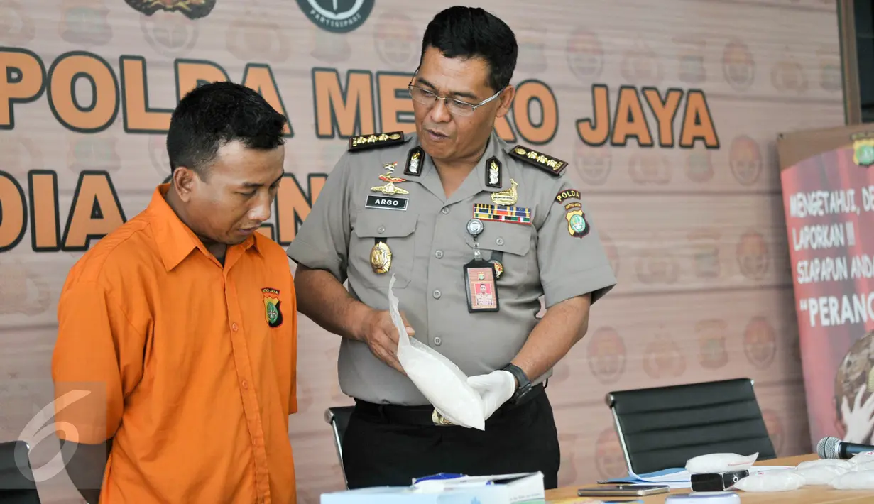 Petugas memperlihatkan barang bukti dan tersangka saat rilis di Polda Metro Jaya, Jakarta, Rabu (22/2). Dari tangan tersangka, Polisi berhasil mengamankan narkotika jenis sabu sebanyak 2,5kg. (Liputan6.com/Yoppy Renato)