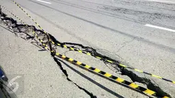 Kondisi jalan retak di Kabupaten Pidie Jaya, Aceh, Kamis (8/12). Gempa berkekuatan 6,5 SR pada Rabu pagi menyebabkan sejumlah ruas jalan retak dan mengalami kerusakan. (Liputan6.com/Angga Yuniar)