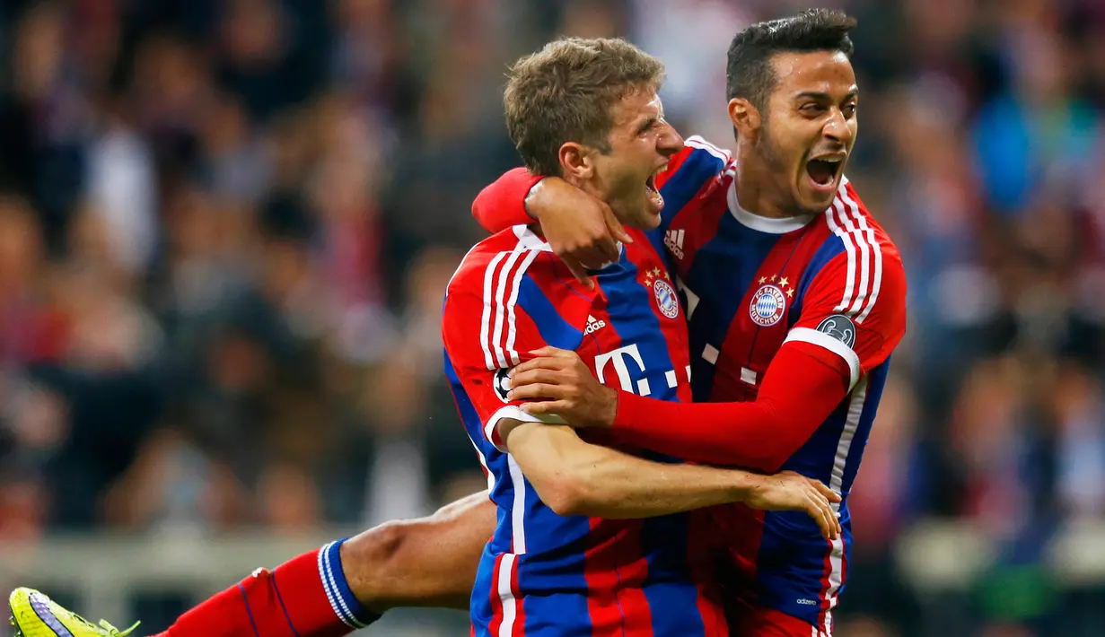 Penyerang Bayern Muenchen, Thomas Muller (kiri) merayakan selebrasi bersama Thiago Alcantara usai mencetak gol di leg kedua perempat final Liga Champions di Allianz Arena,  Rabu (22/4/2015). Bayern Muenchen menang 6-1 atas Porto. (Reuters/Michael Dalder)
