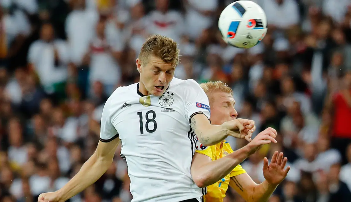 Gelandang Jerman, Toni Kroos (kiri) berebut bola udara dengan gelandang Viktor Kovalenko di kualifkasi grup C Piala Eropa 2016 di Stadion Stade Pierre-Mauroy, Perancis, (12/6). Jerman menang atas Ukraina dengan skor 2-0. (REUTERS/Pascal Rossignol) 