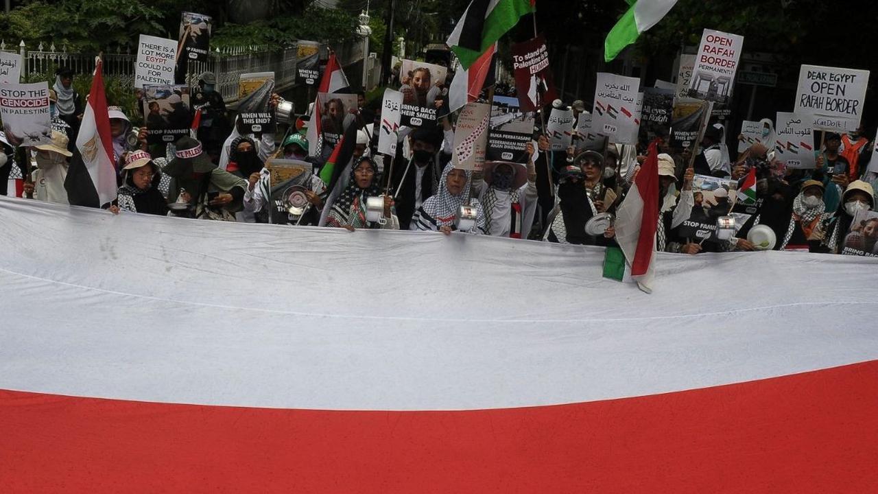 Peserta aksi bela Palestina membentangkan bendera merah putih di depan Kedutaan Besar Mesir, Jakarta, Senin (4/3/2024). Foto merdeka.com / Imam Buhori