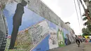 Pengendara sepeda melintas di depan dinding berhias mural bertema Islami di Gang Abdul Jabar, Jagakarsa, Jakarta, Senin (28/5). (Liputan6.com/Herman Zakharia)