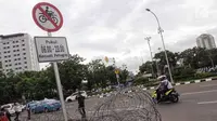 Plang pemberitahuan larangan sepeda motor melintas yang terpampang di jalan Medan Merdeka Barat, Jakarta, Selasa (7/11). Anies meminta ada perubahan agar motor bisa difasilitasi di Jalan MH Thamrin. (Liputan6.com/Faizal Fanani)