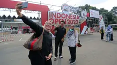 Sejumlah pengunjung melakukan swafoto di pintu gerbang Istora Senayan menjelang Indonesia Open 2023 pada Senin (12/06/2023). Ketua Panpel Armand Darmadji mengungkapkan bahwa tahun ini akan menjadi edisi terakhir turnamen BWF Super 1000 tersebut di Istora Senayan sebelum dipindahkan ke arena yang lebih besar yakni Indoor Multifunction Stadium. (Bola.com/Bagaskara Lazuardi)