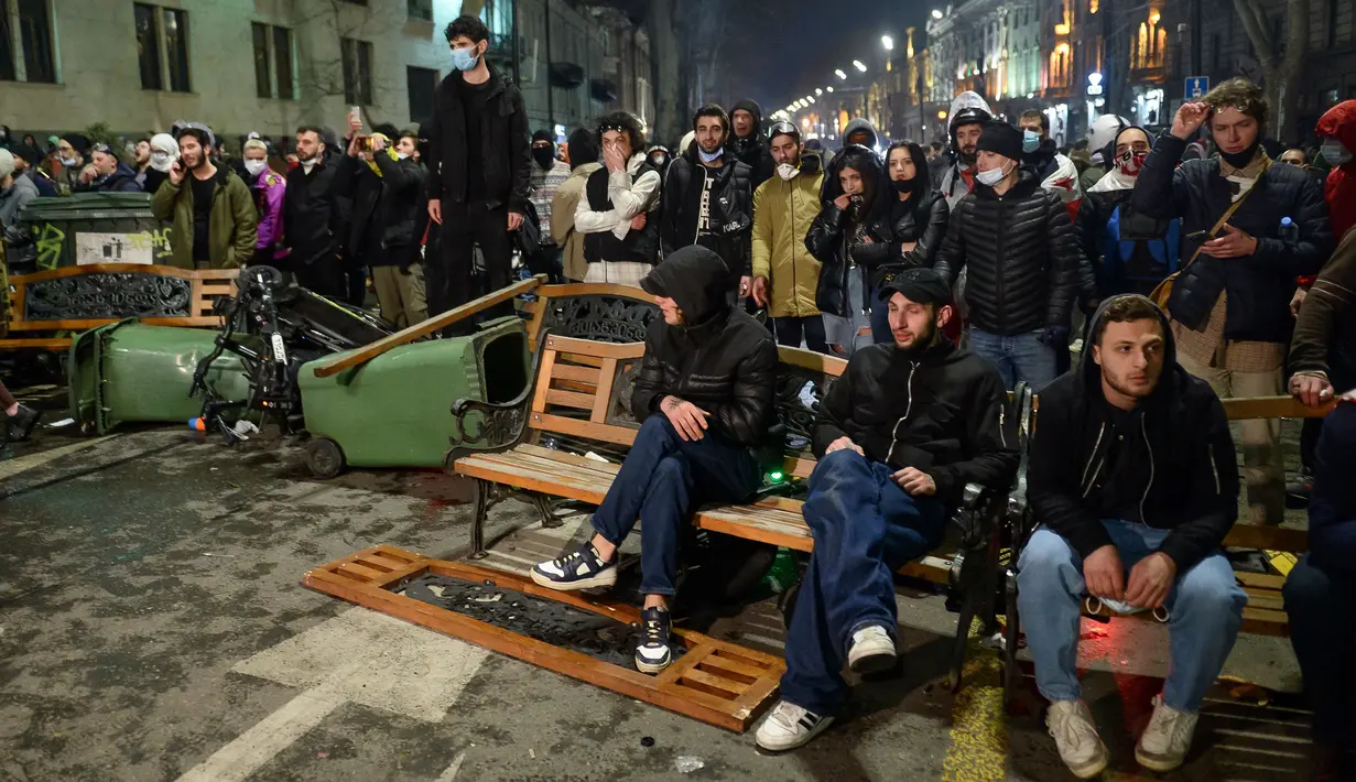 Para pengunjuk rasa berkumpul pada barikade seberang garis polisi di luar Gedung Parlemen Georgia, Tbilisi, Georgia, Kamis (9/3/2023). Partai penguasa Georgia menyatakan akan menarik tanpa syarat RUU "Agen Asing" setelah negara pecahan Uni Soviet itu diguncang demonstrasi besar-besaran selama dua malam. (AP Photo/Zurab Tsertsvadze)