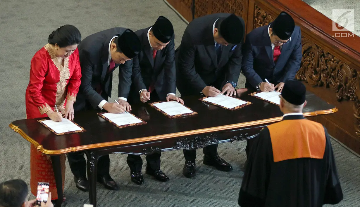 Puan Maharani (kiri), Aziz Syamsuddin, Sufmi Dasco Ahmad, Rachmat Gobel dan Muhaimin Iskandar saat menandatangani berkas acara pelantikan Ketua dan Wakil Ketua DPR RI 2019-2024 di kompleks parlemen, Senayan, Jakarta, Selasa (1/10/2019). (Liputan6.com/Johan Tallo)