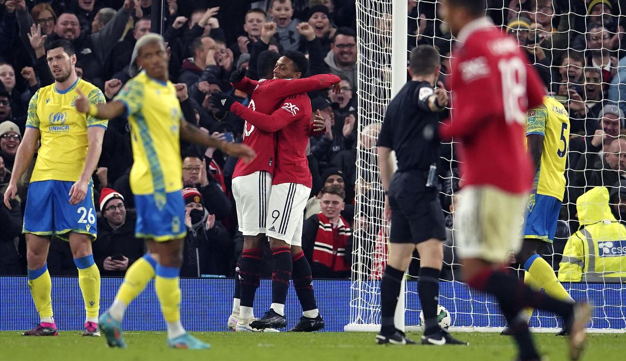 Pemain Manchester United, Anthony Martial memeluk rekannya Marcus Rashford setelah mencetak gol pertama timnya ke gawang Nottingham Forest pada laga leg kedua Semifinal Carabao Cup 2022/2023 di Old Trafford, Manchester, Kamis (02/02/2023) WIB. Gol Martial terjadi pada menit ke-73 melalui assist Marcus Rashford. (AFP/Paul Ellis)