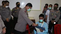 Kapolda Sulteng memberikan Surat kenaikan pangkat dari Kapolri kepada Briptu Ilham Suhayar di RS Bhayangkara Palu. (Foto: Humas Polda Sulteng).