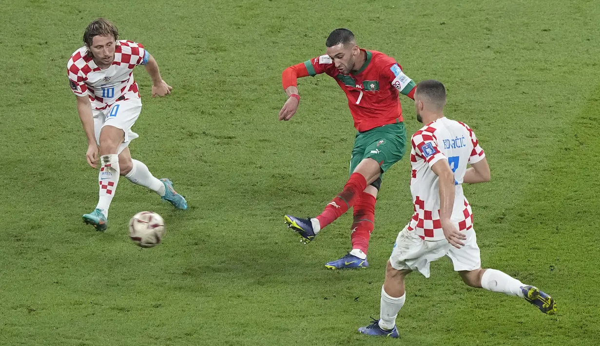 Keadaan imbang membuat Maroko terus melancarkan serangan. Hakim Ziyech (tengah) yang dikawal Luka Modric (kiri) berhasil melakukan tendangan ke gawang Kroasia, namun upaya tersebut masih gagal. (AP Photo/Martin Meissner)