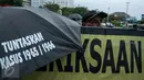 Sejumlah peserta kamisan membawa payung saat aksi Kamisan ke-482 di depan Istana Merdeka, Jakarta, Kamis (23/2). Mereka menuntut Presiden Jokowi untuk menuntaskan segala kasus pelanggaran HAM. (Liputan6.com/Gempur M Surya) 