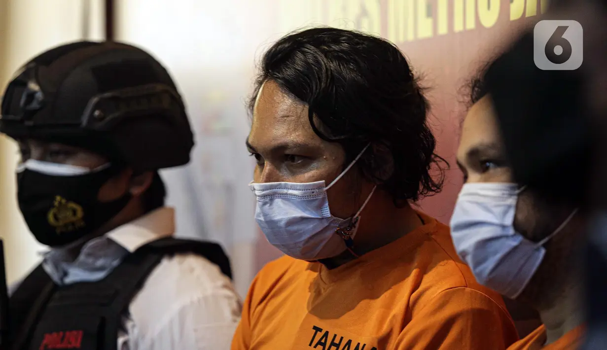 Vokalis grup band Deadsquad Daniel Mardhany (tengah) dan rekannya saat rilis kasus narkoba di Polres Jakarta Utara, Senin (3/5/2021). Kapolres Metro Jakarta Utara Kombes Pol Guruh Arif Darmawan mengatakan dalam penangkapan diamankan tembakau sintetis serta obat prohiper. (Liputan6.com/Faizal Fanani)