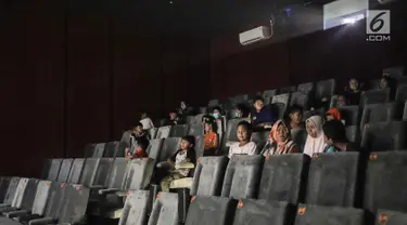 Anak-anak bersiap menyaksikan film di Indiskop atau Bioskop Rakyat di dalam Pasar Jaya Teluk Gong, Penjaringan, Jakarta Utara, Rabu (3/6/2019). Bioskop rakyat ini masih dalam tahap uji coba yang nantinya akan diresmikan pada tanggal 10 Juli 2019 mendatang. (Liputan6.com/Faizal Fanani)