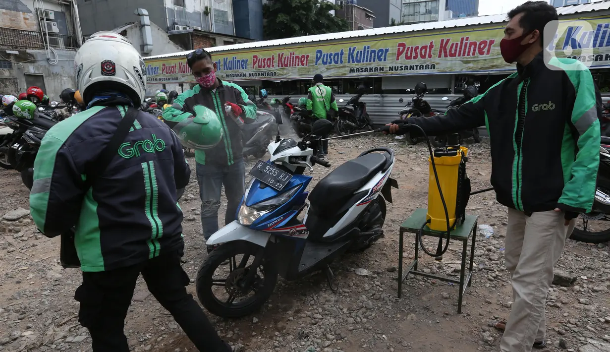 Pengemudi ojek online melakukan penyemprotan disinfektan sebelum mengangkut penumpang di Shelter Sudirman, Jakarta, Senin (8/6/2020). Pemprov DKI mulai mengizinkan ojek daring maupun konvensional mengangkut penumpang di PSBB transisi dengan menerapkan protokol kesehatan. (Liputan6.com/Angga Yuniar)