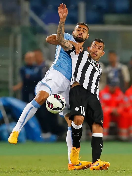 Penyerang Juventus, Carlos Tevez berebut bola dengan bek Lazio Nascimento Mauricio pada final Coppa Italia di Olimpico Roma, Italia, Rabu (20/5/2015). Juventus menang 2-1 atas Lazio. (Reuters/Giampiero Sposito)