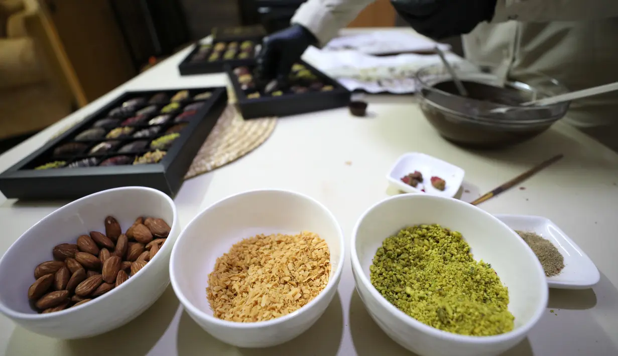 Wanita Palestina bernama Sojood Silwadi membuat kurma berlapis cokelat di rumahnya di Kota Nablus, Tepi Barat, 15 November 2020. Dia menemukan cara mendapatkan sumber penghasilan stabil dengan membuat kurma cokelat isi kacang dan menjualnya kepada pelanggan via media sosial. (Xinhua/Ayman Nobani)
